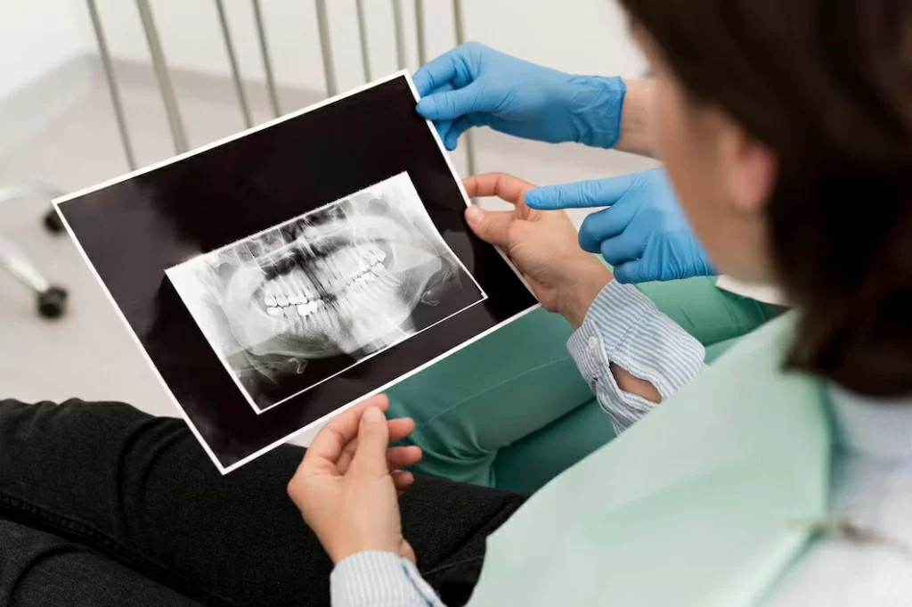 female-patient-looking-radiography-her-teeth-with-dentist_23-2148985804.jpg